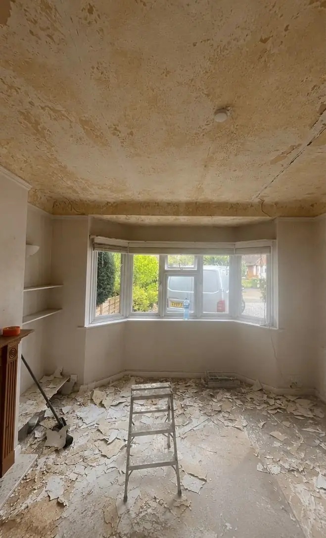 Bay-window lounge before, with the ceiling stripped back