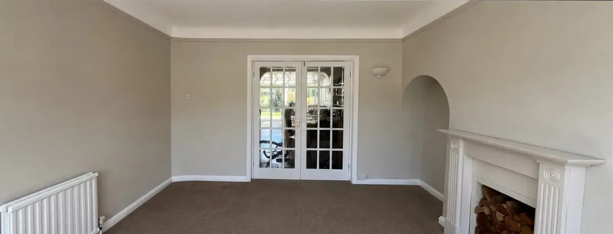 Living room with fireplace and French doors after redecoration