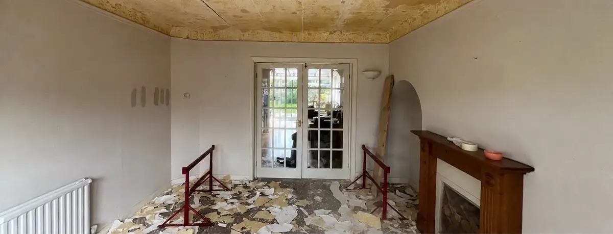 Living room with fireplace and French doors before